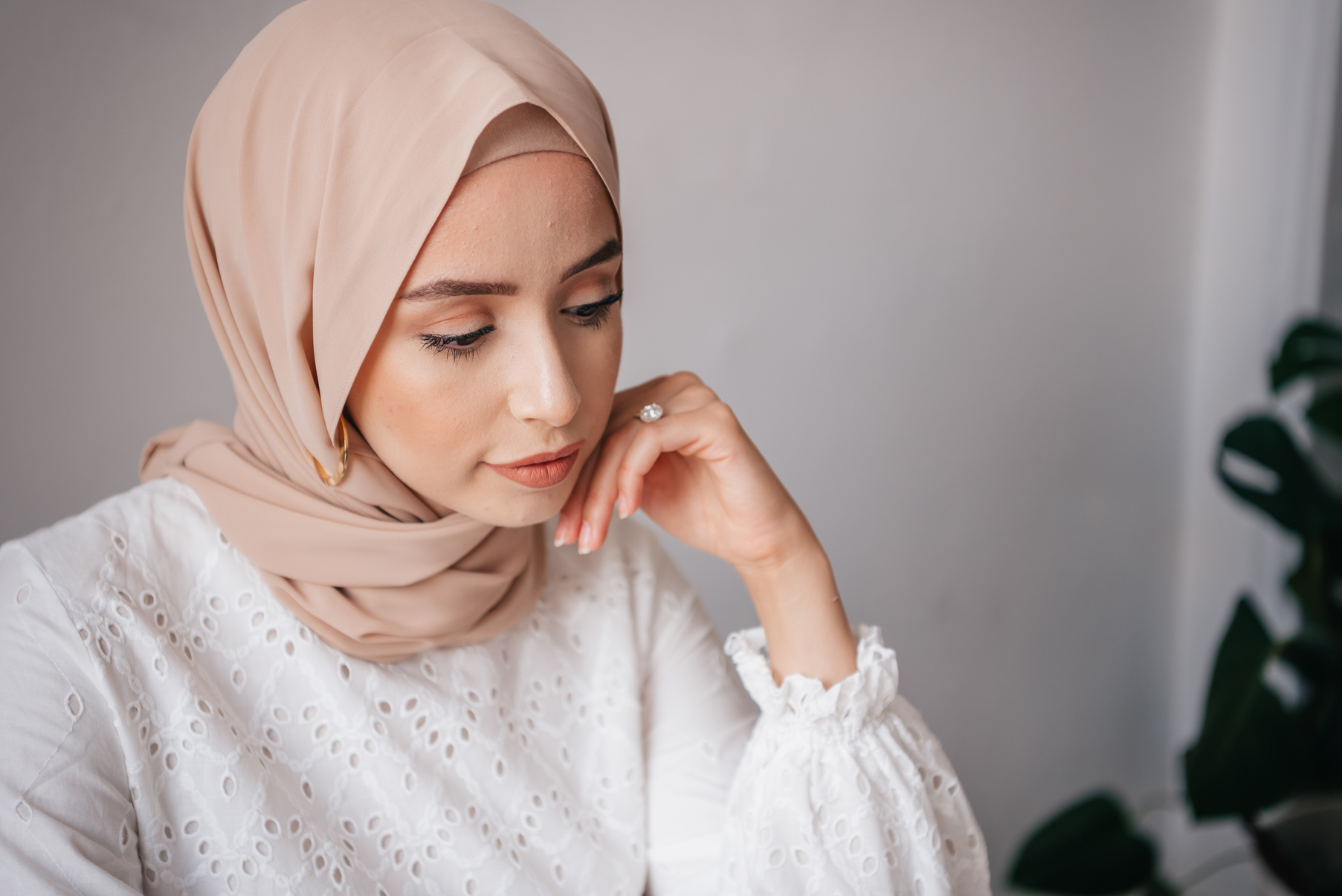 Woman in White Hijab Covering Her Face With Her Hand